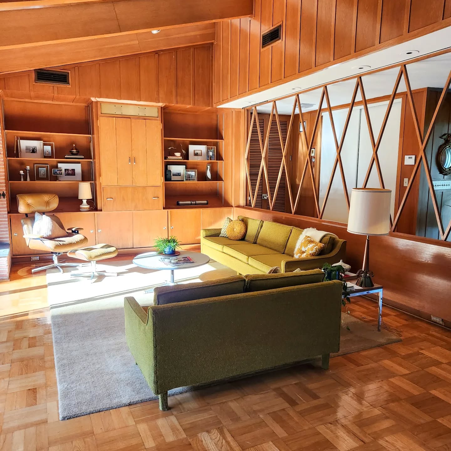 6. Mid-century Eames Lounge Chair with Geometric Sunburst Wall Art and Teal Accents