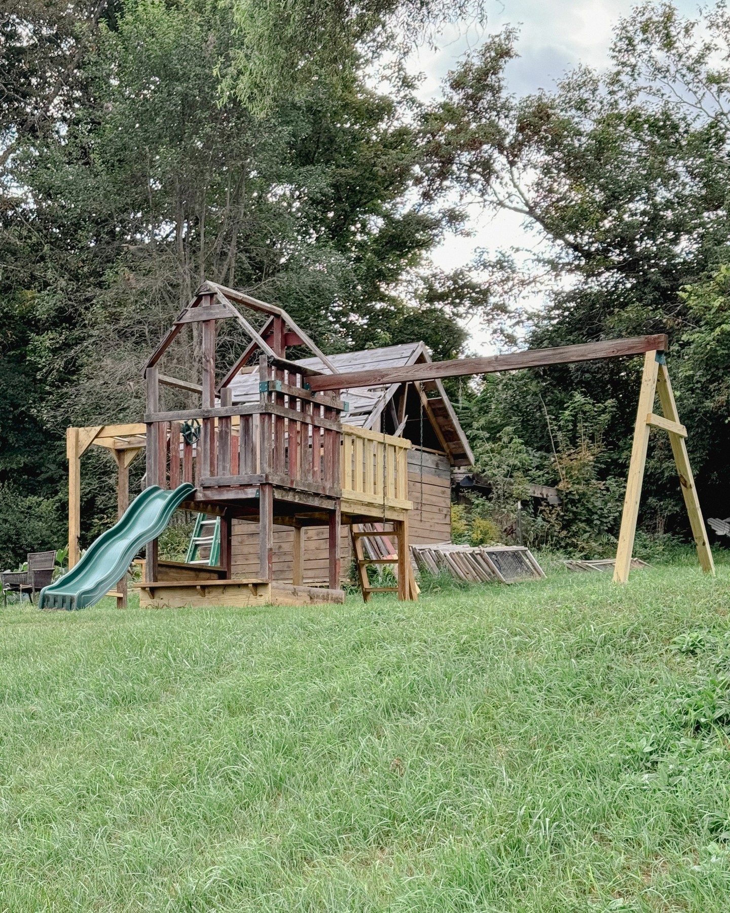 14. Vibrant Climbing Wall and Slide Combo with Rustic Log Frame and Surrounding Greenery