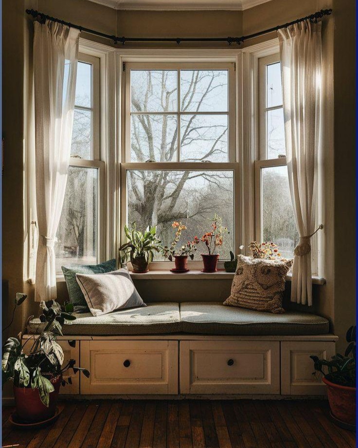 1. Bay Window Transformed Into a Cozy Nook with a Patchwork Quilt and Vintage Bookshelves