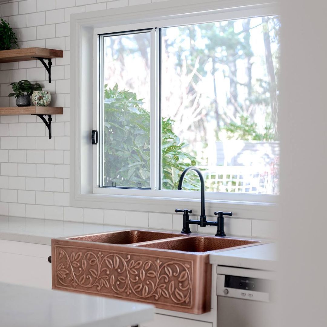 1. a Copper Accentuated Farmhouse Sink with Industrial Piping