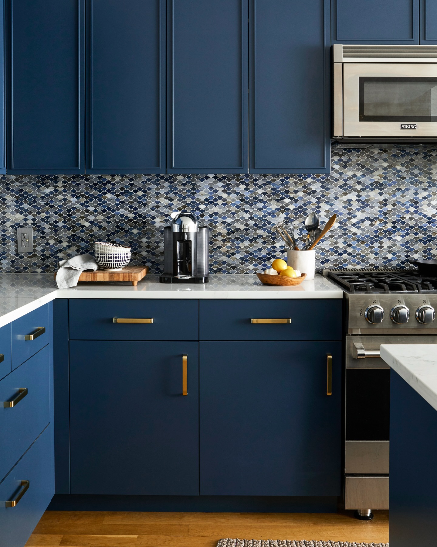22. Cobalt Blue Cabinets with Geometric White Tiles and Copper Accents