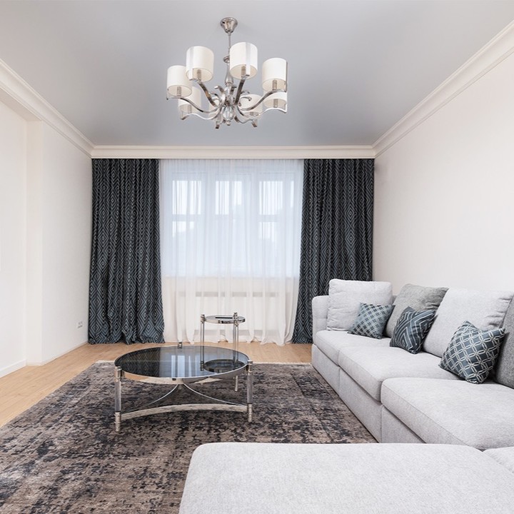 15. Velvet Armchair and Geometric Rug Define Cozy Nook In Sunlit Rectangle Living Room
