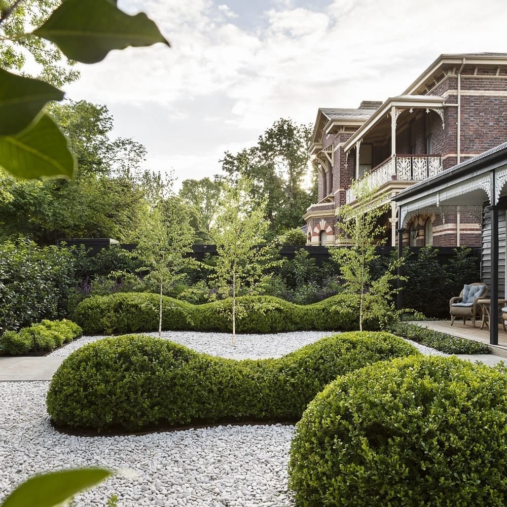 1. Lush Boxwood Hedge with Interwoven Jasmine Vines Fronting a Red Brick Colonial
