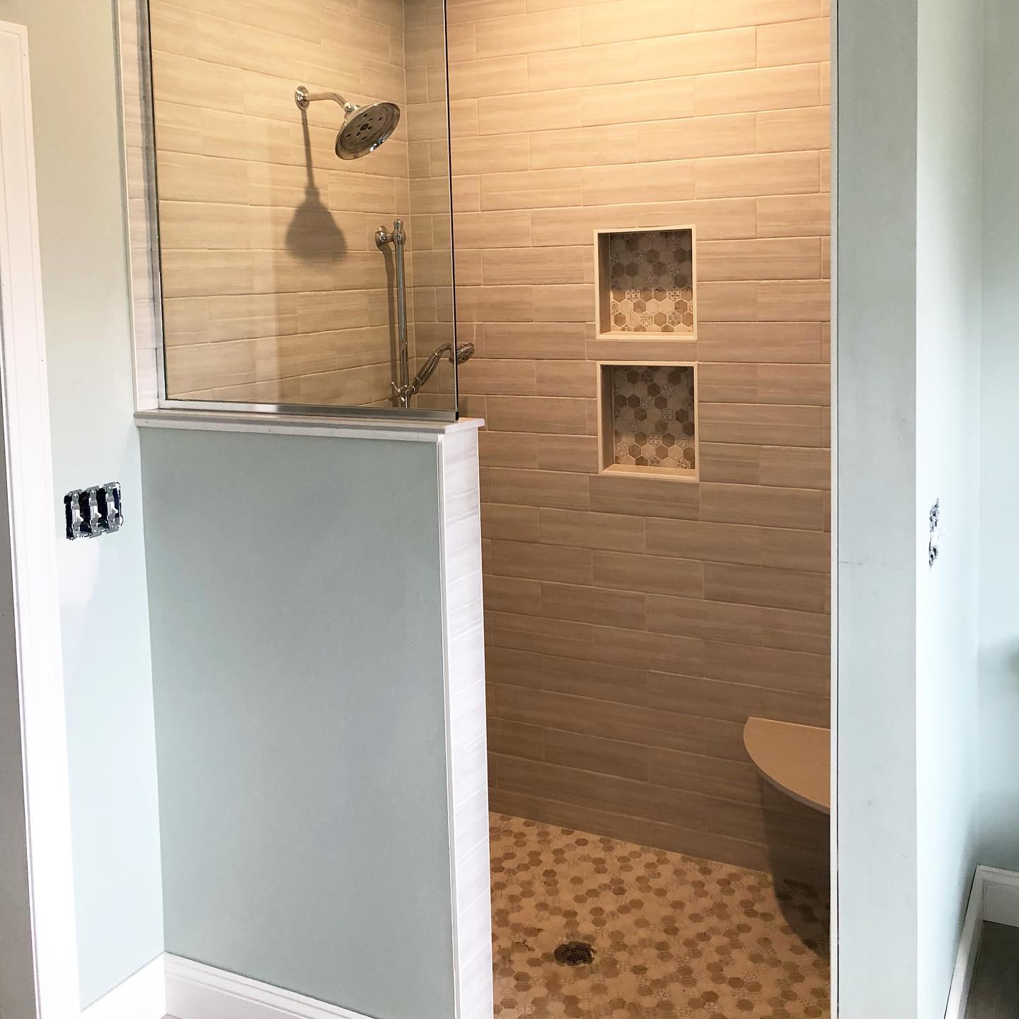 26. the Undulating Glass Partition with Mosaic Accents and Sculptural Faucet