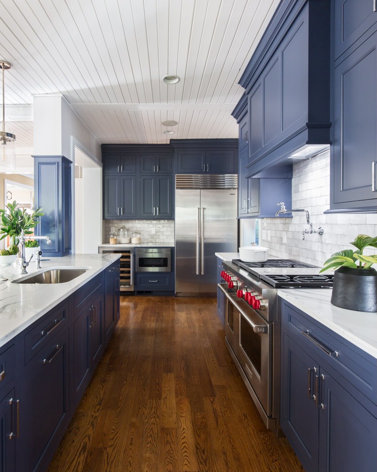 28. Cobalt Cabinets and Geometric Copper Tiles In a Sunlit Blue Kitchen