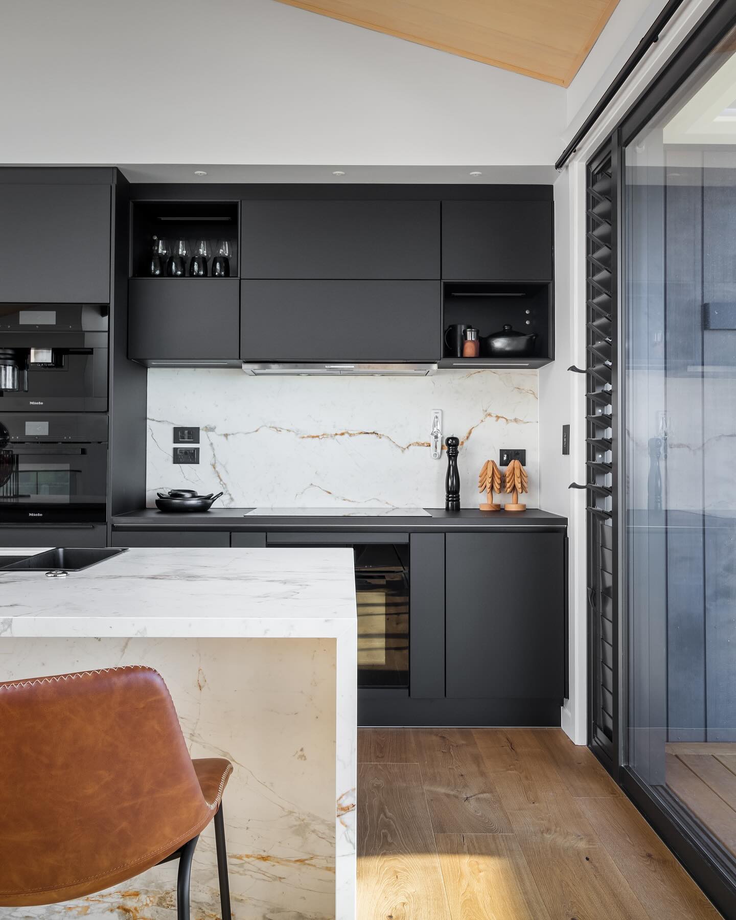 13. Glossy Black Cabinets Meet Matte White Countertops In Geometric Harmony