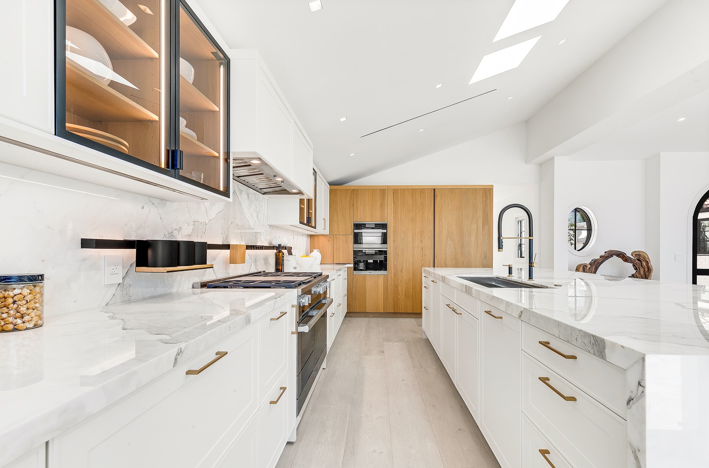 15. Velvet-cushioned Armchair Nooks with Eclectic Book Arrangement Above Kitchen Cabinets