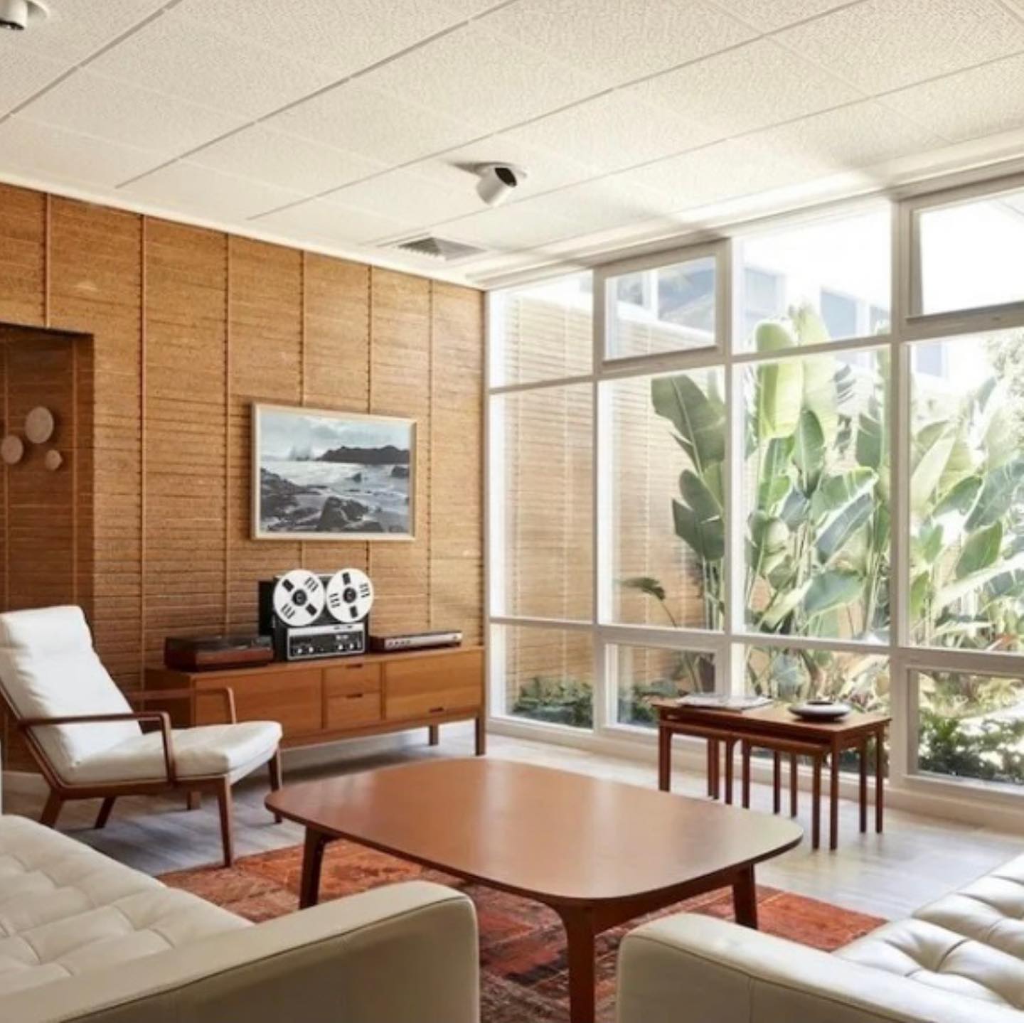 7. Mid-century Modesty with a Teal Twist: the Oval Mirror and Geometric Rug Ensemble