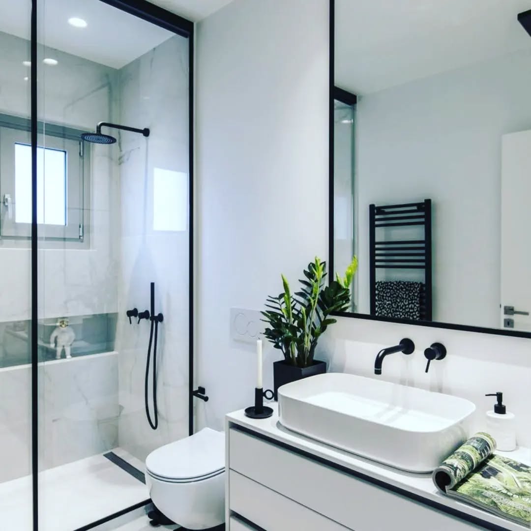 6. Black and White Mosaic Tiles Dance Around a Floating Sink Oasis