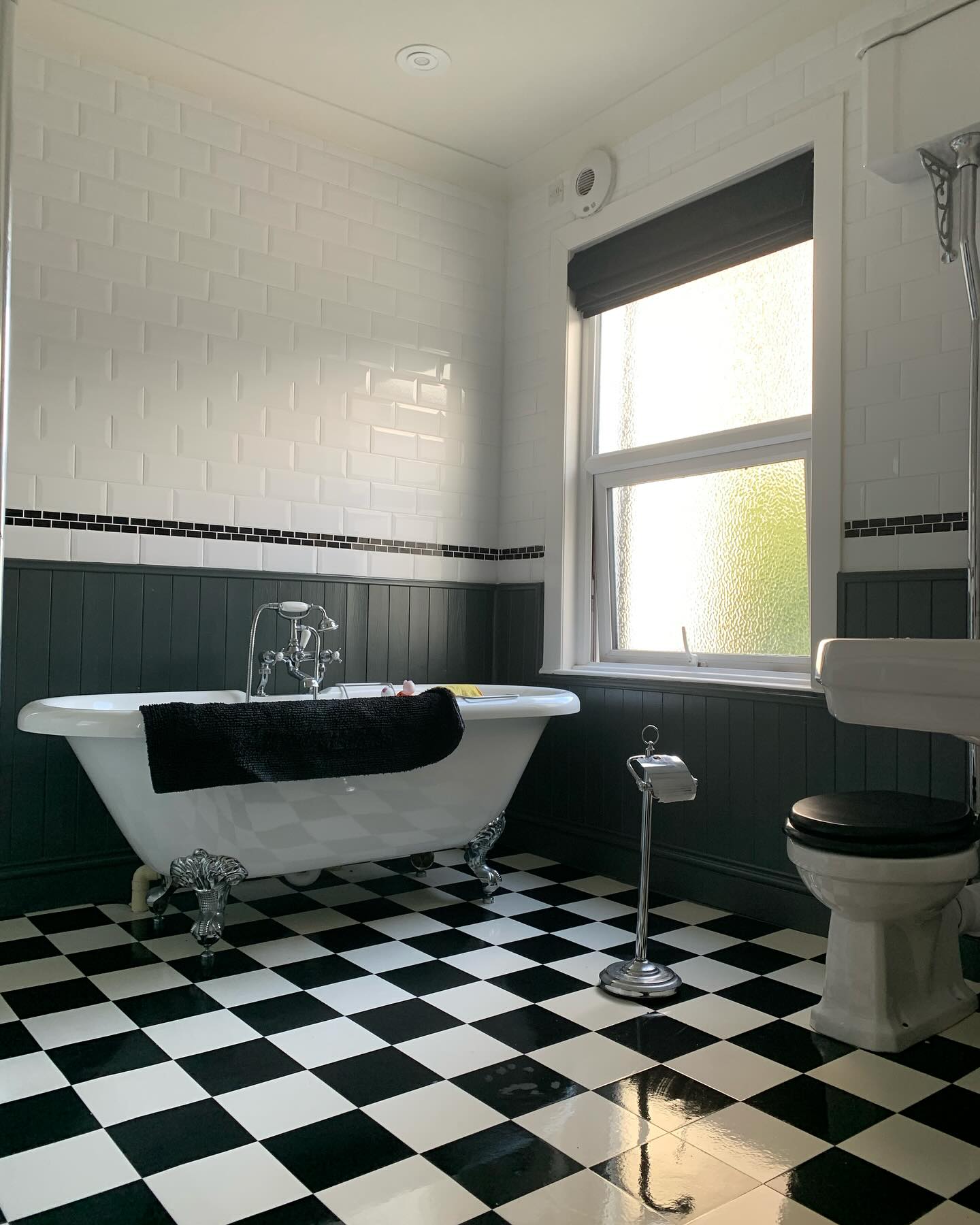 18. Moonlit Mosaic Marvel: Black and White Hexagonal Tiles with Circular Mirror Accent