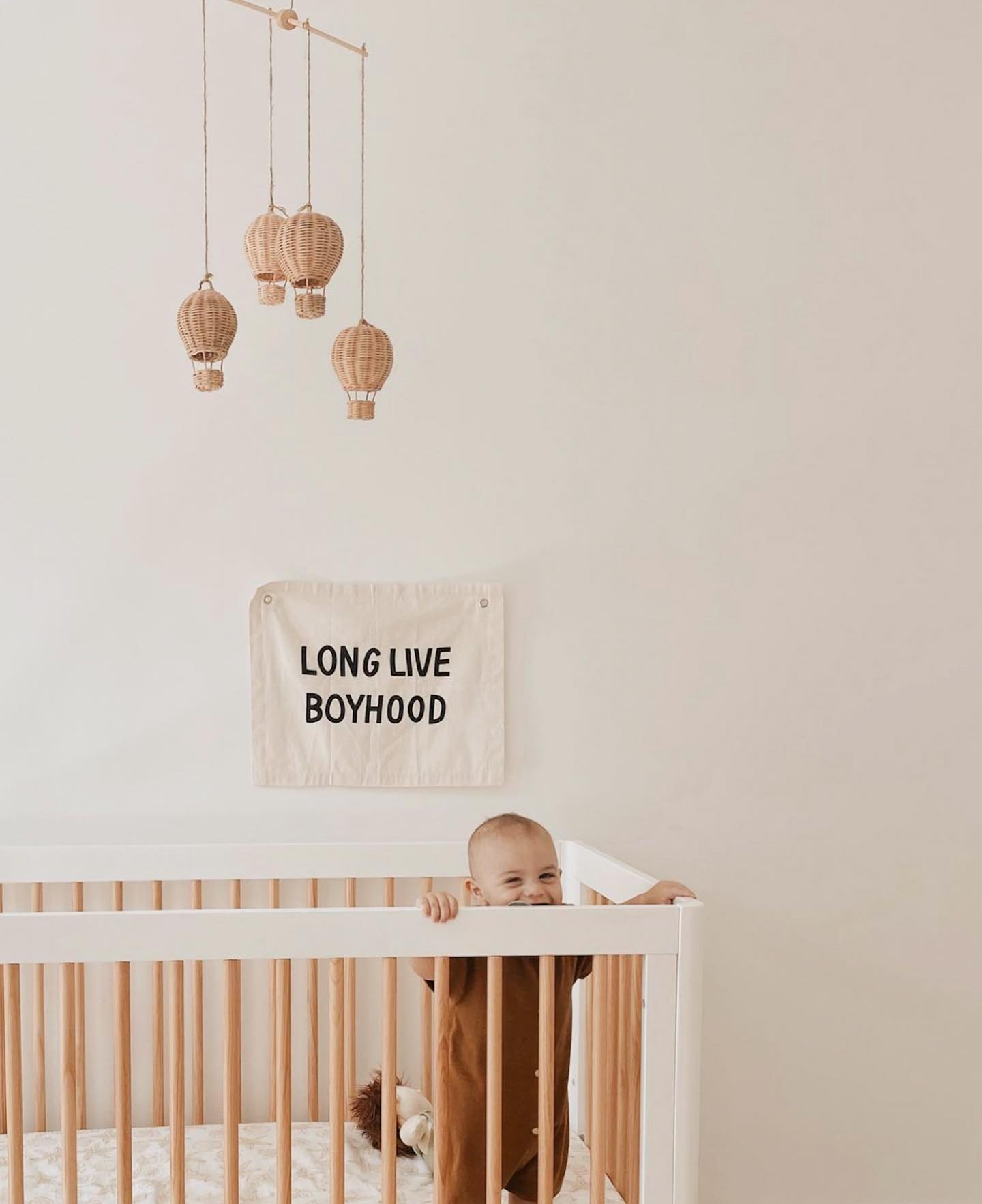 12. Soft Blush Canopy Over Vintage Crib with Geometric Mobile