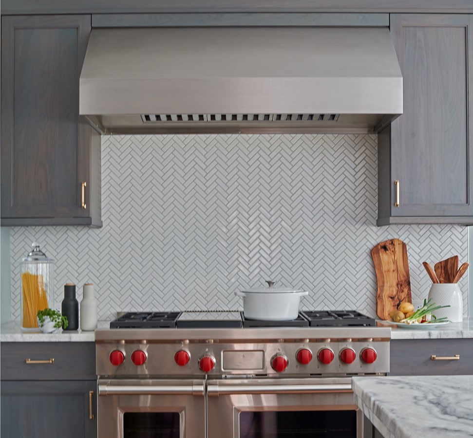 19. White Marble Waterfall Edge Backsplash with Geometric Brass Inlay