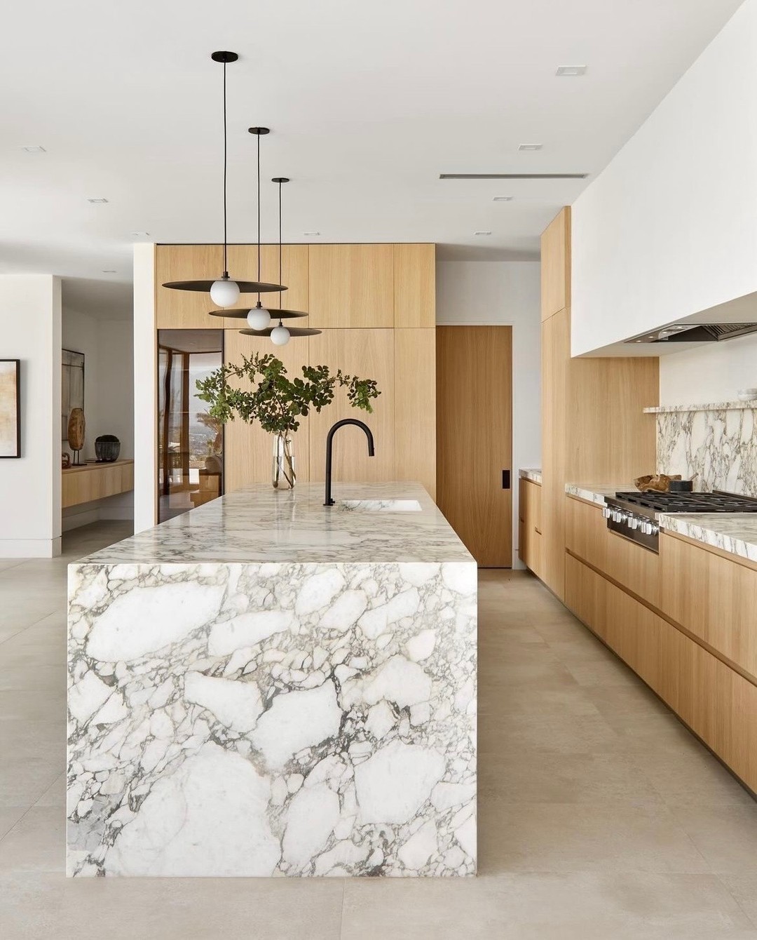 22. Granite Waterfall Edge Meets Industrial Chic: a Kitchen Island with Riveted Steel Panels