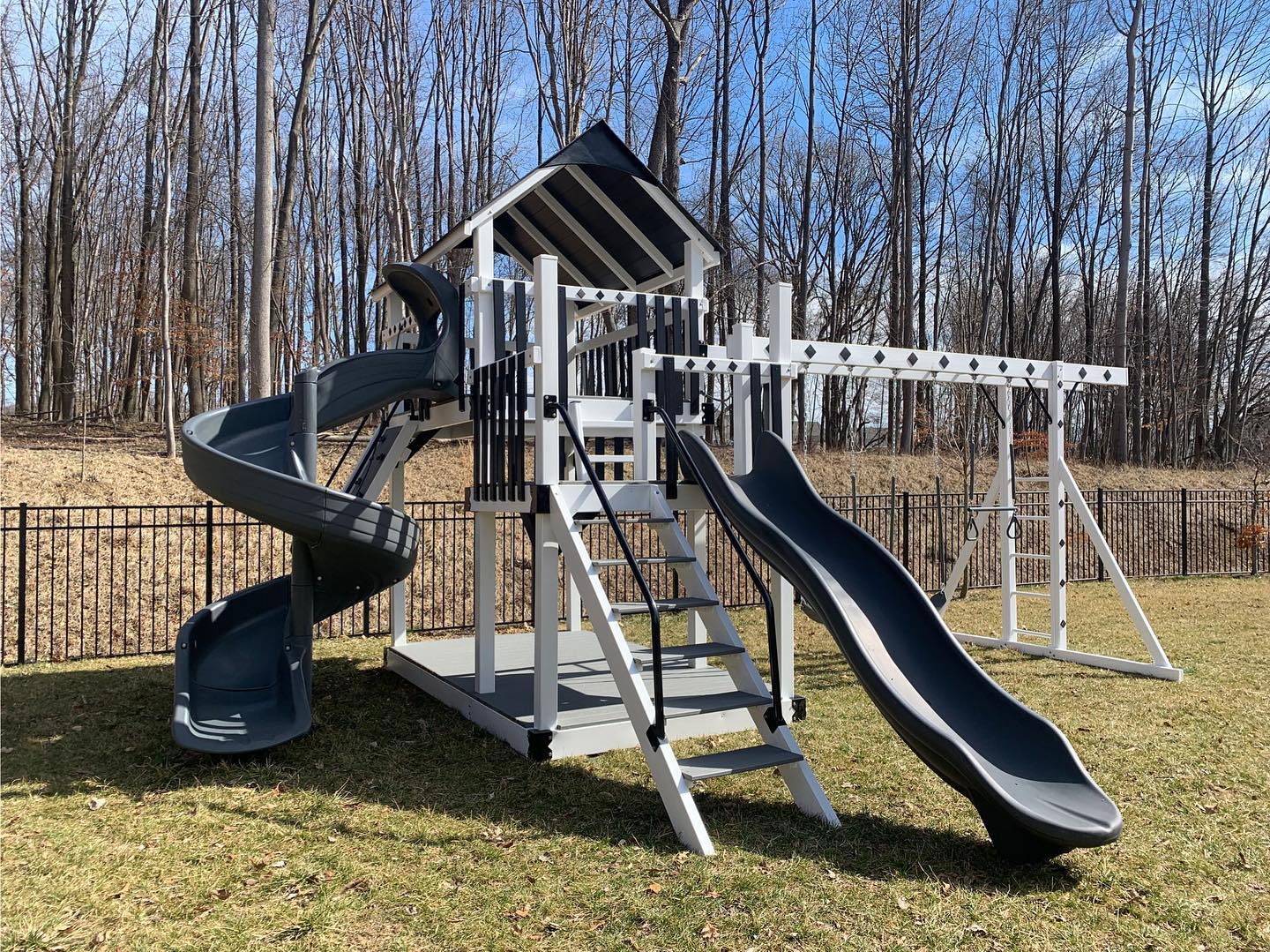 15. Vibrant Blue Slide and Wooden Seesaw Amidst Lush Green Foliage