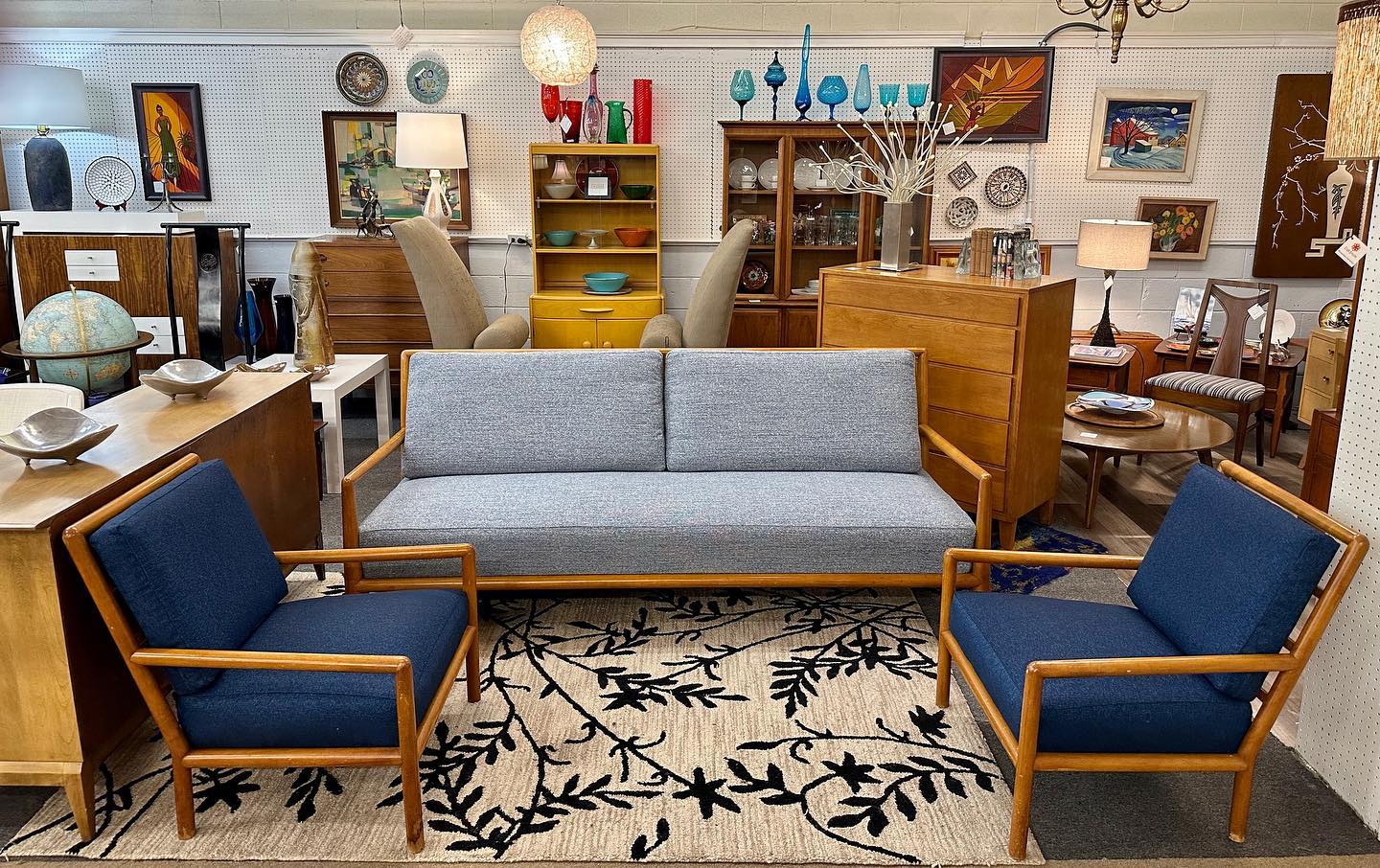 22. Mid-century Armchair with Geometric Cushion In Vibrant Teal Against Warm Wood Paneling